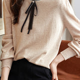 Knitted top with ruffled lace tie decoration