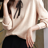 Knitted top with ruffled lace tie decoration